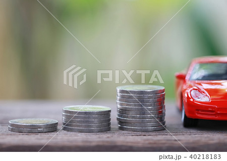 Silver coin of pile with red car model in concept savings to buy a new car. 40218183