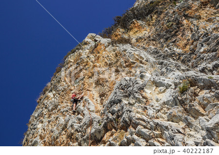 athletic woman climbs a mountain near the sea on a hot summer day athletic woman climbs a mountain near the sea on a hot summer day 40222187
