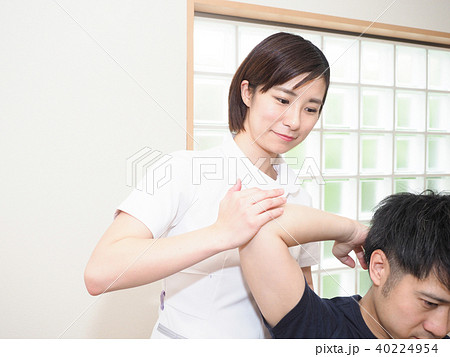腕をほぐす女性マッサージ師の写真素材