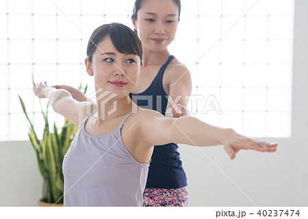 ヨガスタジオでヨガレッスンを受ける若い日本人女性とインストラクター 40237474