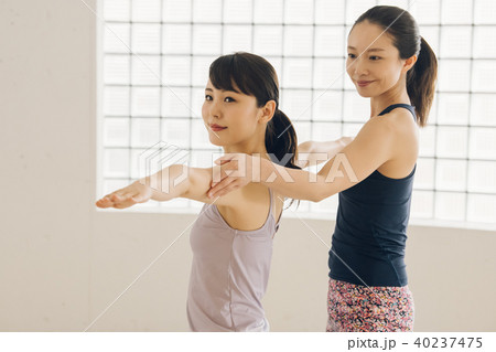 ヨガスタジオでヨガレッスンを受ける若い日本人女性とインストラクター ヨガスタジオでヨガレッスンを受ける若い日本人女性とインストラクター 40237475