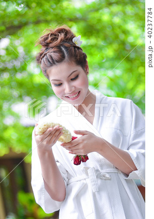 Beautiful girl dress in Bathrobe holding flower 40237784