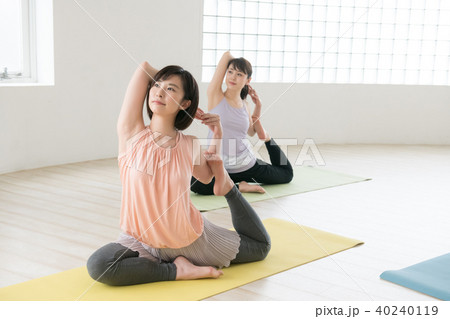 ヨガスタジオでヨガレッスンを受ける若い日本人女性 40240119