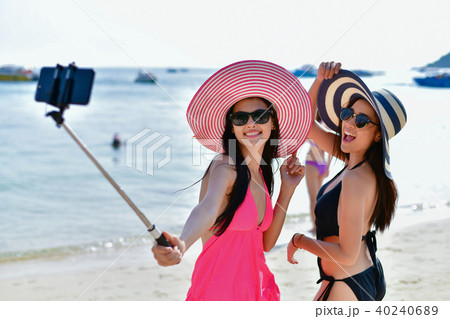 Swimsuit Concept. Beautiful girl wearing a swimsuit playing mobi Swimsuit Concept. Beautiful girl wearing a swimsuit playing mobi 40240689
