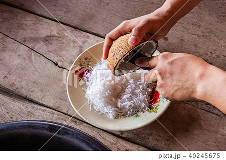 Woman using hand scraping coconut put the plate. 40245675