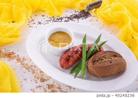 The pork sausage fried on oil is served with musta 40248236