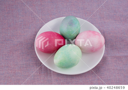 multicolored painted Easter eggs on plate 40248659