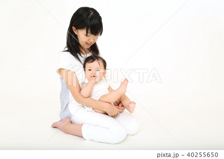 若いお母さんに抱かれる女の子の赤ちゃんの写真素材