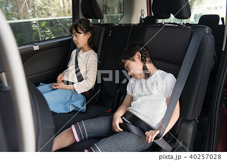 ファミリードライブ 疲れて眠る小学生の子供たちの写真素材 [40257028