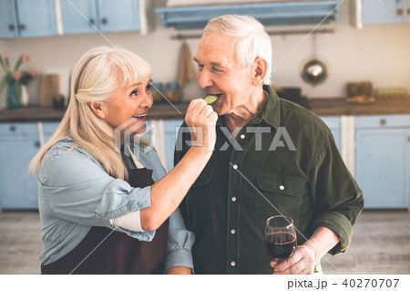 Excited pensioners tasting healthy vegetable in cook room 40270707
