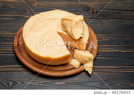 Whole round Head and pieces of parmesan or parmigiano Whole round Head and pieces of parmesan or parmigiano 40270935