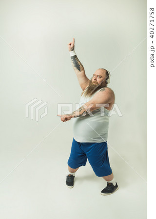 Excited fat man dancing with headphones 40271758