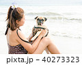 Girl playing with pug dog on the beach 40273323
