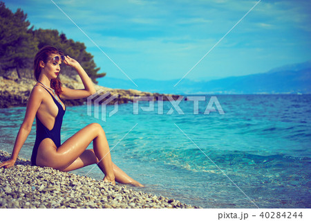 slim attractive woman posing in blue waters of Adriatic sea beac slim attractive woman posing in blue waters of Adriatic sea beac 40284244