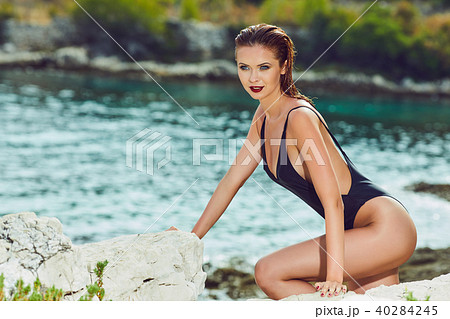 slim attractive woman posing in blue waters of Adriatic sea beac 40284245