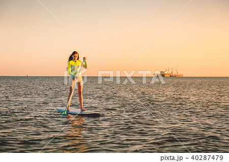Sporty young girl stand up paddle surfing Sporty young girl stand up paddle surfing 40287479