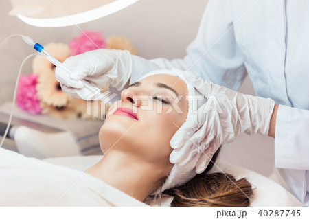 Beautiful woman relaxing during non-invasive facial treatment Beautiful woman relaxing during non-invasive facial treatment 40287745