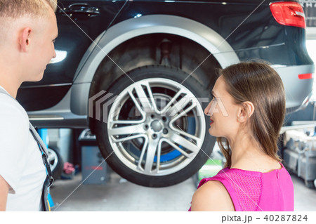 Beautiful woman looking happy at a reliable auto mechanic Beautiful woman looking happy at a reliable auto mechanic 40287824