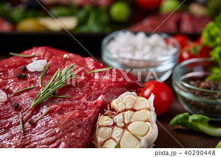 Still life of raw beef meat with vegetables on wooden plate over vintage background, top view 40290448
