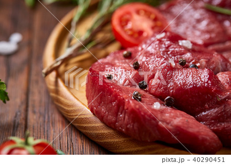 Still life of raw beef meat with vegetables on wooden plate over vintage background, top view 40290451