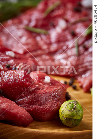 Still life of raw beef meat with vegetables on wooden plate over vintage background, top view 40290454