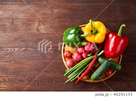 Wooden plate with vegetables for a vegetarian salad on rustic wooden background, close-up, selective 40291155