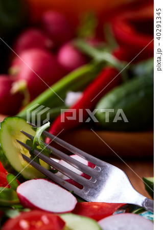Creative fresh vegetable salad with ruccola, cucumber, tomatoes and raddish on white plate 40291345