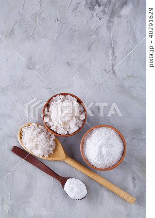 Conceptual composition of salt and pepper on spoons and bowls over light background, top view, close 40291629