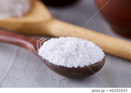 Conceptual composition of salt and pepper on spoons and bowls over light background, top view, close 40291635