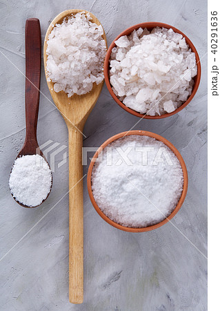 Conceptual composition of salt and pepper on spoons and bowls over light background, top view, close 40291636
