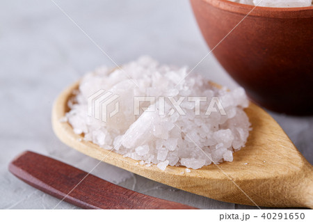 Conceptual composition of salt and pepper on spoons and bowls over light background, top view, close 40291650