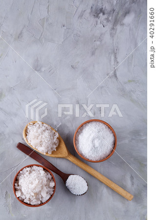 Conceptual composition of salt and pepper on spoons and bowls over light background, top view, close 40291660