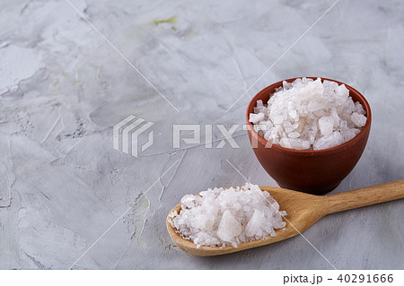 Conceptual composition of salt and pepper on spoons and bowls over light background, top view, close 40291666