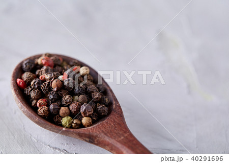 Conceptual composition of salt and pepper on spoons and bowls over light background, top view, close 40291696