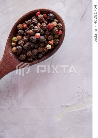 Conceptual composition of salt and pepper on spoons and bowls over light background, top view, close 40291704