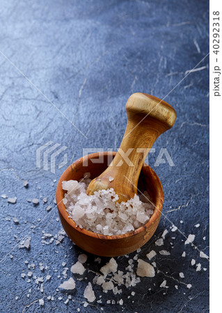 Large white sea salt in a natural wooden bowl on white background, top view, close-up, selective 40292318