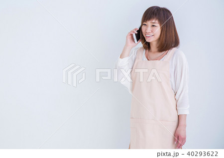 電話するエプロン姿の笑顔の女性 電話するエプロン姿の笑顔の女性 40293622