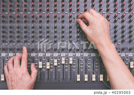 male sound engineer hands working on audio mixer 40295003