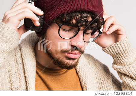 Portrait of a young man with hat and headphones in a studio. Portrait of a young man with hat and headphones in a studio. 40298814