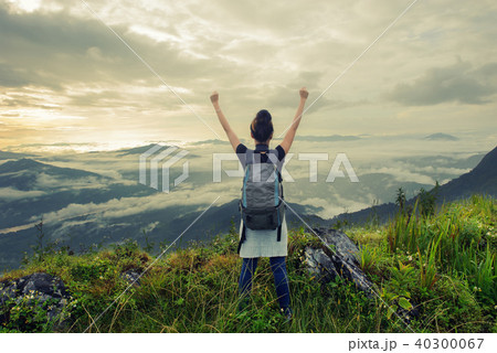 woman tourists arms up on the hill 40300067