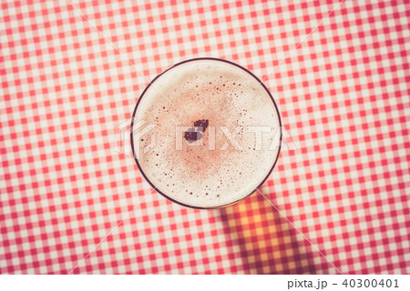 Beer glass on red checkered background 40300401
