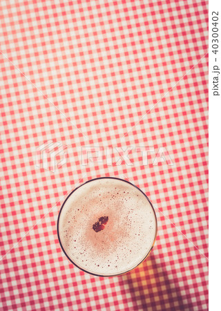 Beer glass on red checkered background Beer glass on red checkered background 40300402