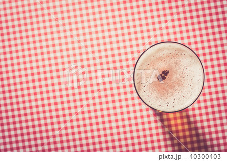 Beer glass on red checkered background Beer glass on red checkered background 40300403