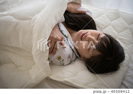 寒くて布団から出られない冷え症の女性 40309412