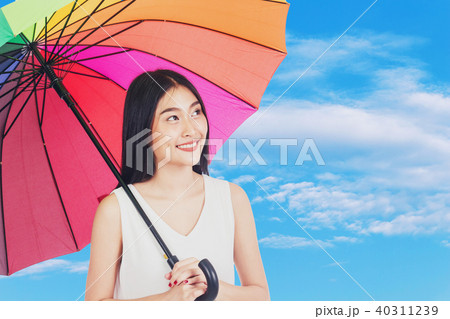 Young woman holding umbrella on blue sky Young woman holding umbrella on blue sky 40311239