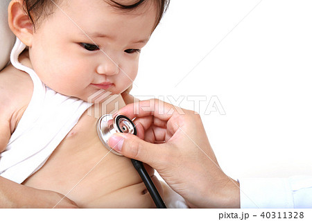 聴診器を胸に当てられ診察を受ける赤ちゃんの写真素材