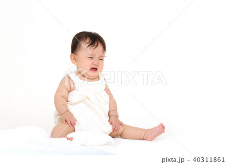 白い背景でお座りして泣く赤ちゃん 白い背景でお座りして泣く赤ちゃん 40311861