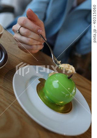 Close-up of woman's hand holding fork to eating cake. 40315060