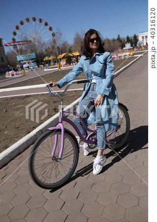 Stylish young woman riding a bicycle. Stylish young woman riding a bicycle. 40316120