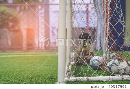 boy sitting in Soccer goal net focus on the net 40317991